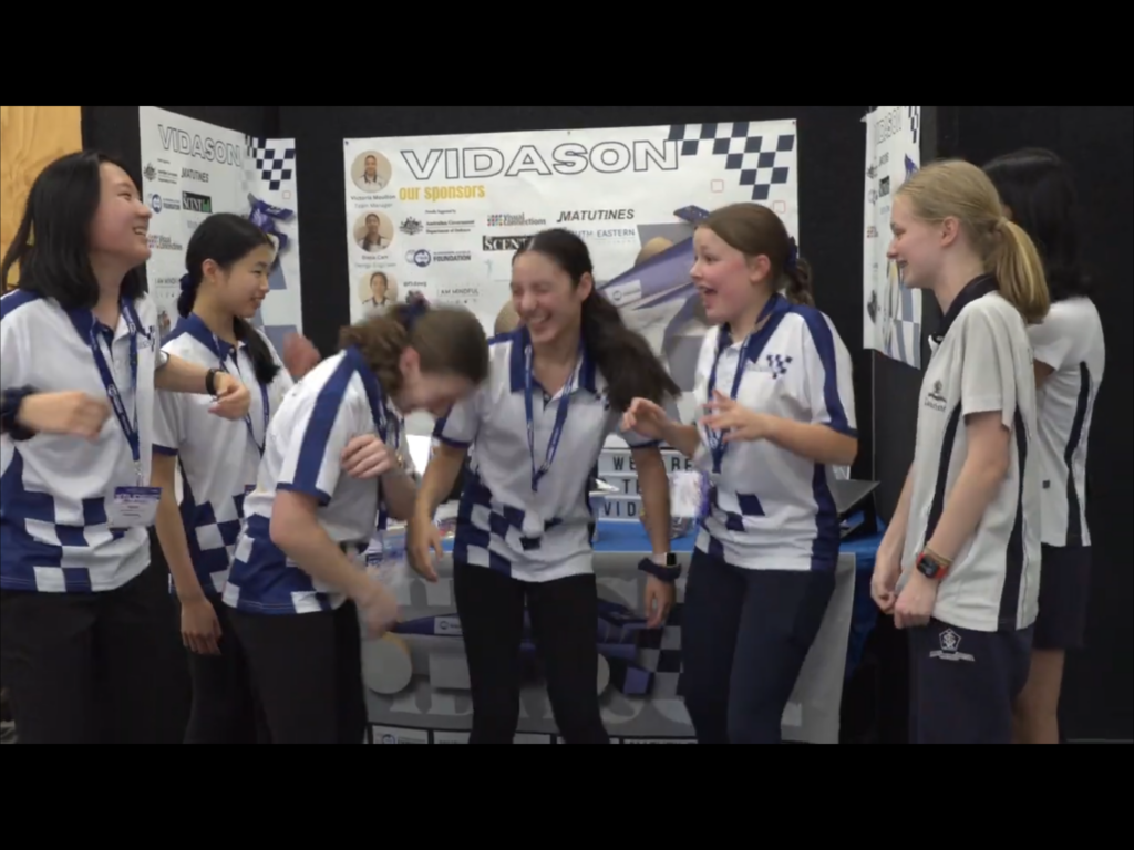 A Team Of Students At F1 In Schools Victorian State Final, Having A Moment Of Laughter And Enjoyment Through The Day At Their Trade Booth